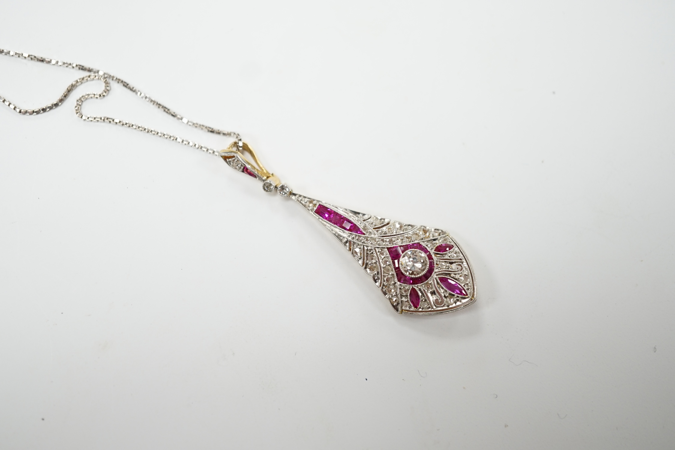 A Belle Époque pierced yellow metal, pink sapphire and diamond cluster set drop pendant, 44mm, on a later 9ct white gold chain, 44cm, gross weight 5.2 grams. Good condition.